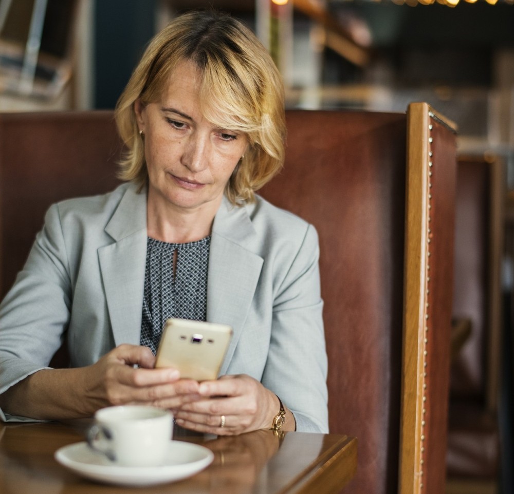 Business woman looking contemplatively at phone